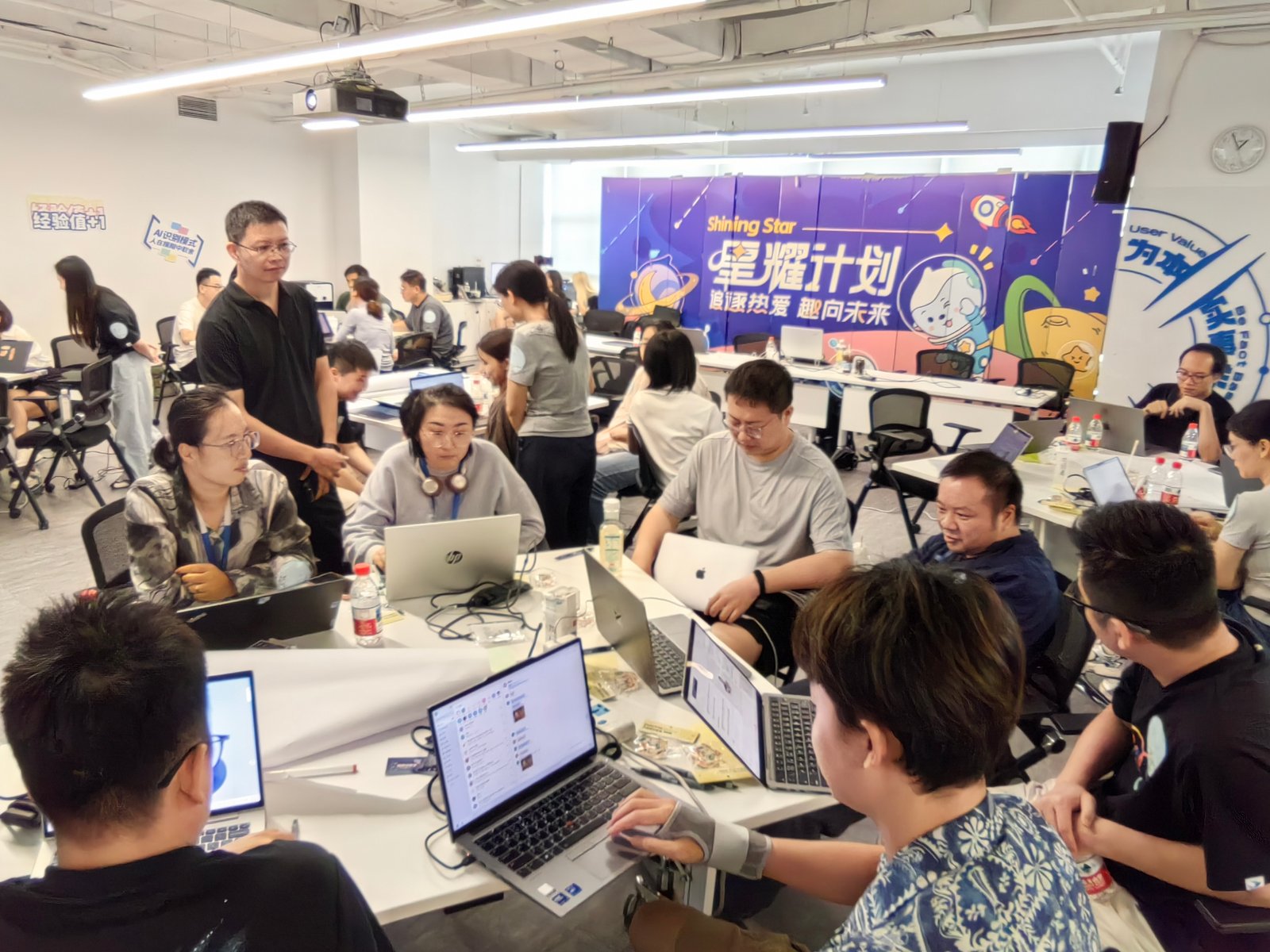 企业 AI 应用活动现场，讲师在学员座位间做一对一指导