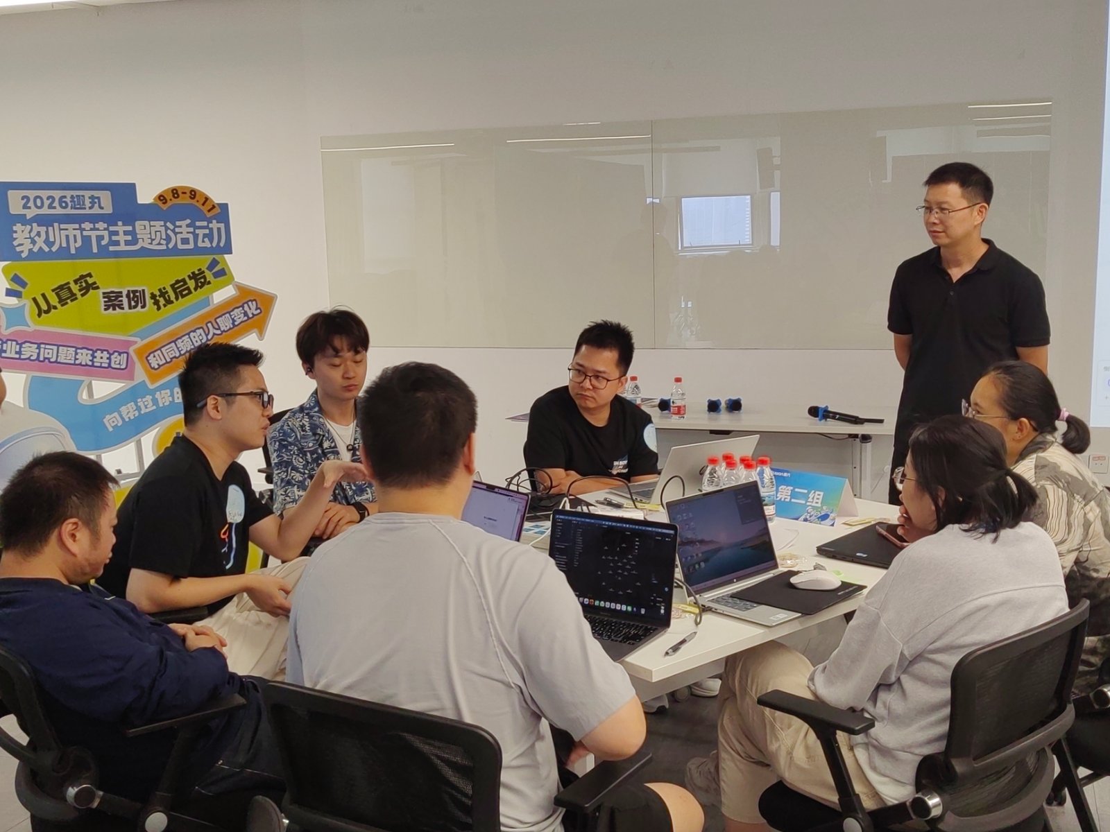 企业 AI 共创工作坊现场，学员分组用电脑实操