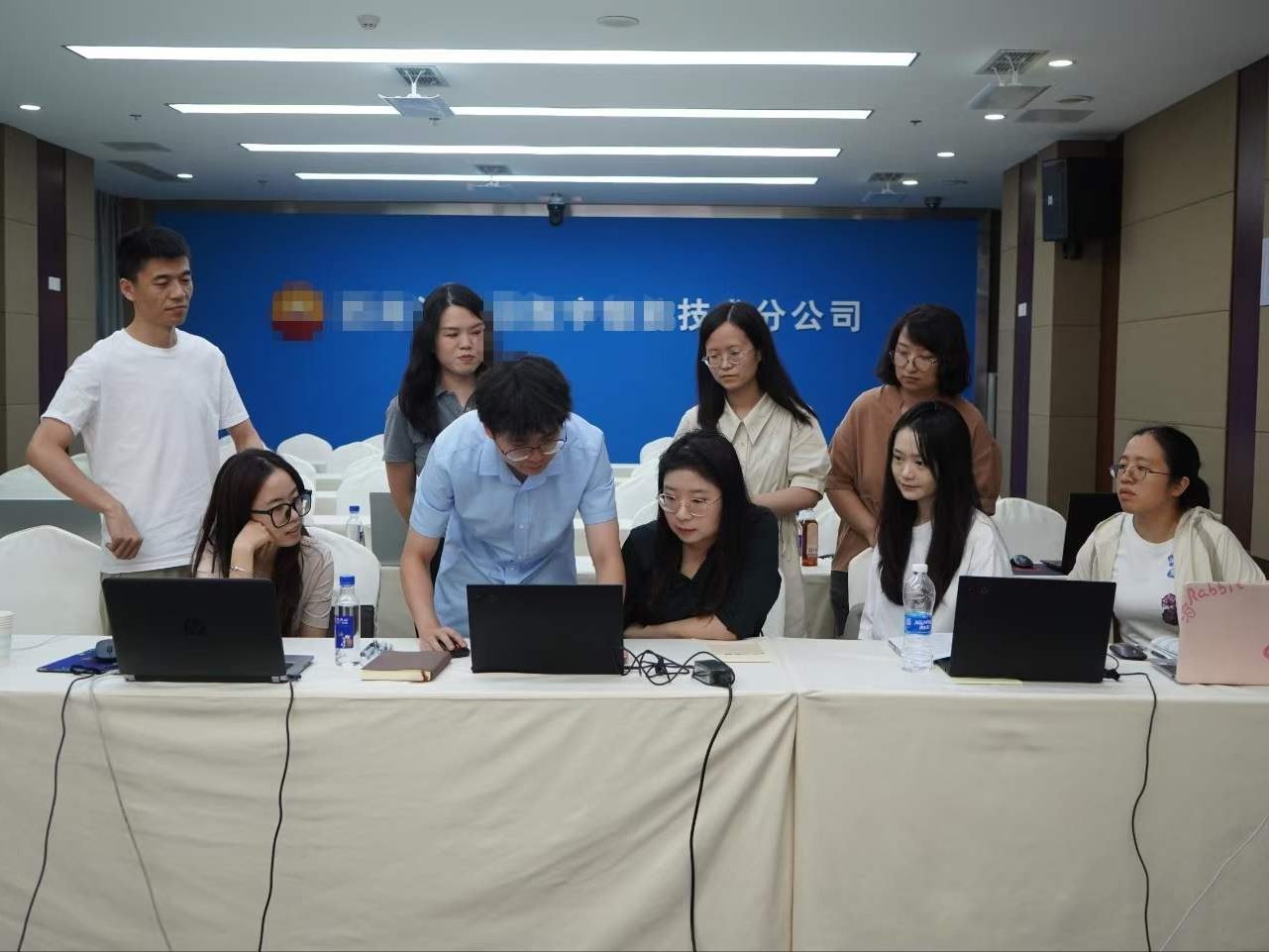 中石油西南油气田 AI 智能体培训现场，学员围坐长桌用笔记本同步实操