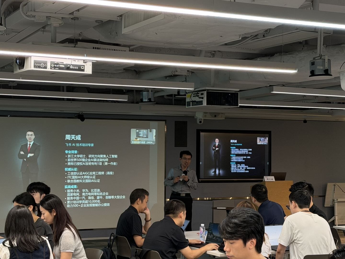 天成老师在客户香港教室授课，左侧大屏展示个人专业背景介绍