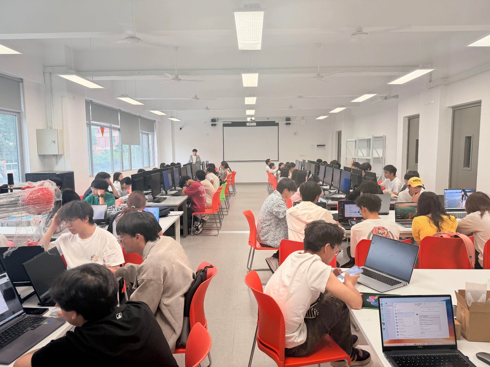 培训现场，约 100 名大一新生与学院教师同步上机跟随演示操作